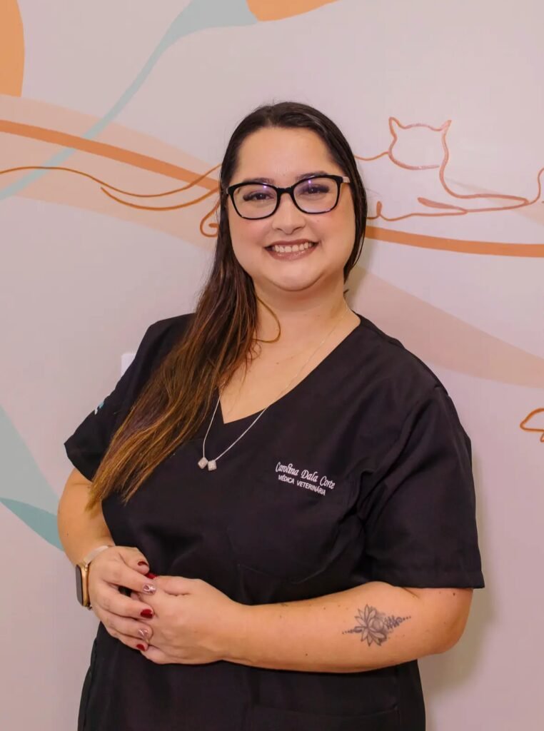Dra. Carol em pé, usando uniforme preto na Clínica Veterinária Amigo Fiel