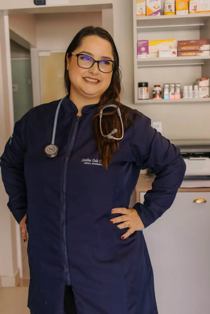 Dra. Carol usando jaleco azul e estetoscópio na Clínica Veterinária Amigo Fiel